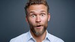 © Nataliia_Trushchenko - Male with curly hair and beard, wearing a light blue shirt, displays a surprised expression, showcasing emotions of excitement and joy against a neutral background, capturing a moment of genuine react