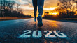 © syhin_stas - New Year 2026 start concept with the word 2026 painted on asphalt road and athlete running forward at sunset, symbolizing fresh goals, plans, motivation, personal growth, copy space banner