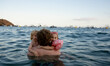 © Westend61 - Father hugging children in sea at the beach on a sunny day