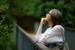 © AlexKriv - Woman enjoying a peaceful moment while looking up at the greenery in a serene outdoor setting