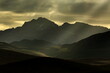 © Travel 'n' Lifestyle - View of sun rays piercing through the dramatic, moody clouds over the rugged, dark mountain ranges, creating a serene yet powerful scene, Deosai National Park, Gilgit Baltistan, Pakistan.