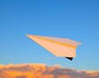 © Andi - Paper airplane soars through a vibrant sunset sky