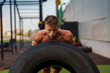 © DusanJelicic - Muscular fitness trainer lifting a large tire during an outdoor workout on a sunny day.