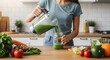 © narumiaegis - Caucasian woman pouring a vibrant green detox smoothie from a blender into a jar, surrounded by fresh organic vegetables and fruits for a healthy lifestyle and clean eating routine in a modern kitchen