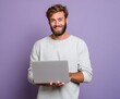 © Imnot99 - A man with a light gray sweatshirt holds a laptop computer against a vibrant purple background, smiling warmly.