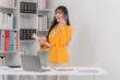 © Kritdanai - Smiling Asian Businesswoman Talking on Phone in Office