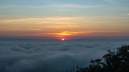 Wall Mural - Time lapse video of dramatic sunrise with fog on a cloudy morning.