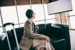 © deagreez - Stylish female professional seated in modern office lounge with urban view and engaging decor for corporate settings