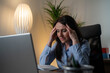 © Nenad - Stressed businesswoman working late on laptop in office, fatigue and overwork concept in professional environment