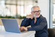 © F8  \ Suport Ukraine - Mature male entrepreneur or executive sitting at work desk using laptop computer technology.