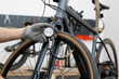 © Mihail - A person is adjusting the tire pressure of a bicycle using a hand-held gauge. The setting is a well-equipped bike shop