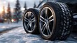 © Oleksandr - Close-up of snow tires on a car, set against a snowy landscape with evergreen trees and a soft, wintery background.