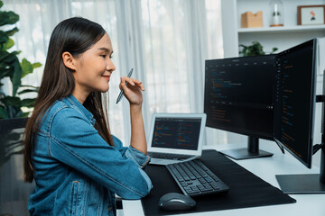 Young Asian IT developer looking online information on pc for beautiful pose with coding program data of website application, wearing jeans shirt. surround by safety analysis two screens. Stratagem.