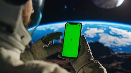 Astronaut using greenscreen phone on moon