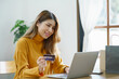 © Charlie's - Woman shopping on laptop holding credit card for Internet online e-commerce shopping spending money Online shopping Mobile phone laptop technology concept