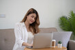 © Charlie's - Business woman working from home. work online on laptop. Asian businesswoman working on sofa online business with social distancing laptop online meeting.
