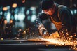 © ffunn - Focused factory worker using angle grinder on metal surface, wearing protective gear, as bright sparks fly in a dim workshop.
