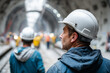 © Olha Havelia - Construction workers in helmets working on a metro tunnel, dramatic perspective