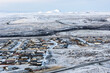 © AmazingAerialAgency - Aerial view of a snow-dusted town nestling under vast, frozen plains reaching towards distant, icy mountains, Grindavik, GrindavÃ­kurbÃ¦r, Iceland.
