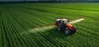 © Daryna - The tractor spraying crops in a lush green agricultural field.