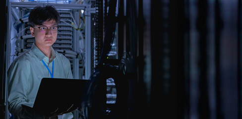 Computer engineer is setting up network in server room,Systems Maintenance Technician,Male engineer working in server room at modern data center