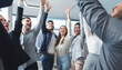 © Prostock-studio - United coworkers raising hands up to celebrate their achievement, colleagues standing in circle