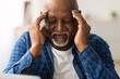 © Prostock-studio - Headache. Senior African American Man Suffering From Migraine Pain Massaging Temples Sitting At Home. Healthcare, Health Problems In Older Age Concept