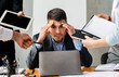 © Prostock-studio - Multitasking. Stressed Businessman At Laptop Touching Head Tired Of Tasks At Work Sitting In Modern Office.