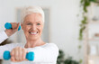 © Prostock-studio - Portrait Of Happy Elderly Woman Exercising With Dumbbells At Home, Having Active Lifestyle On Retirement, Smiling At Camera, Copy Space