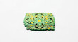 © Bricio - Close up of green and yellow decorative filigree square on a white surface with intricate details