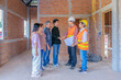 © Verin - asian family inspecting progress of a new house with foreman project manager,talking,discussing,success,handshaking at a building under construction site