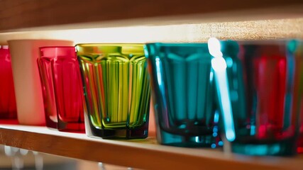Colorful glasses on a wooden shelf