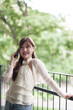© snowing12 - Asian adult woman talks phone outdoor balcony happy relaxed remote work lifestyle enjoying green environment