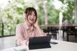 © snowing12 - Asian adult woman freelance working outdoor using tablet headphones for remote study enjoying nature environment