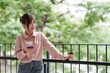 © snowing12 - Asian adult woman freelancer enjoying outdoor work managing business with smartphone and coffee break in a refreshing green environment