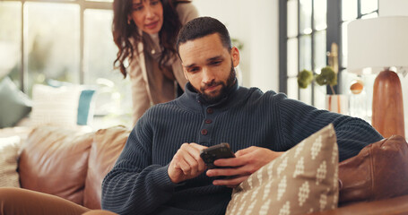 Phone, relax and social media with man on sofa in living room of home for internet browsing. App, frustration and text message with couple in apartment for distraction, ignore or silent treatment