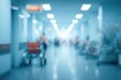 © Echo - Blurred hospital hallway in cool blue tones. A wheelchair sits to the side as people move along a bright corridor filled with light