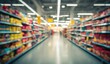 © Mystic - Out-of-focus shot of a supermarket aisle filled with colorful products on shelves, leading to a blurred background under bright, overhead lighting