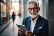 © Snap Realm - Smiling Senior Business Man Using Tablet in Urban Setting