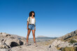 © Martí Rosselló - Confident young woman standing on rocky terrain during a solo hike in the Serra de Tramuntana, Majorca. Concept of travel, hiking, and freedom.