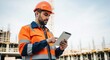 © MonkeyZ - Construction Worker Inspecting Construction Site Blueprint on Tablet with Orange Hard Hat and Vest