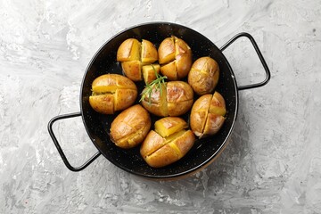 Wall Mural - Tasty baked potatoes with rosemary served on light grey table, top view