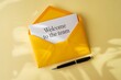 © Risat Designer - A bright yellow envelope with a handwritten welcome to the team note and a black pen on a textured yellow background