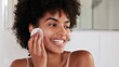 © Loktor - Rutina facial: mujer limpiando su rostro con disco de algodón, Limpieza facial diaria para una piel, exfoliación facial y bienestar natural, mujer sonriendo durante su rutina de skincare