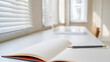 © Hridoy Ahmed - Open notebook and pencil on a white desk with blinds and window in background