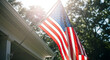 © abu - US flag hanging at entrance of house veranda, viewed from low angle