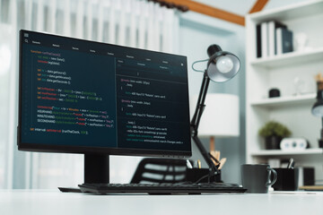 Programming code on computer screen desktop placing on working desk showing intelligent website development coder system running database online with information technology design concept. Infobahn.