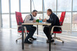 © Михаил Решетников - Two Caucasian men communicating at a business meeting.