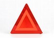 © MacMuroStudio - Bright red reflective warning triangle for roadside emergencies, ensuring safety and visibility on the road for drivers and travelers
