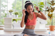 © weedezign - young healthy asian woman listening music while practice yoga at home